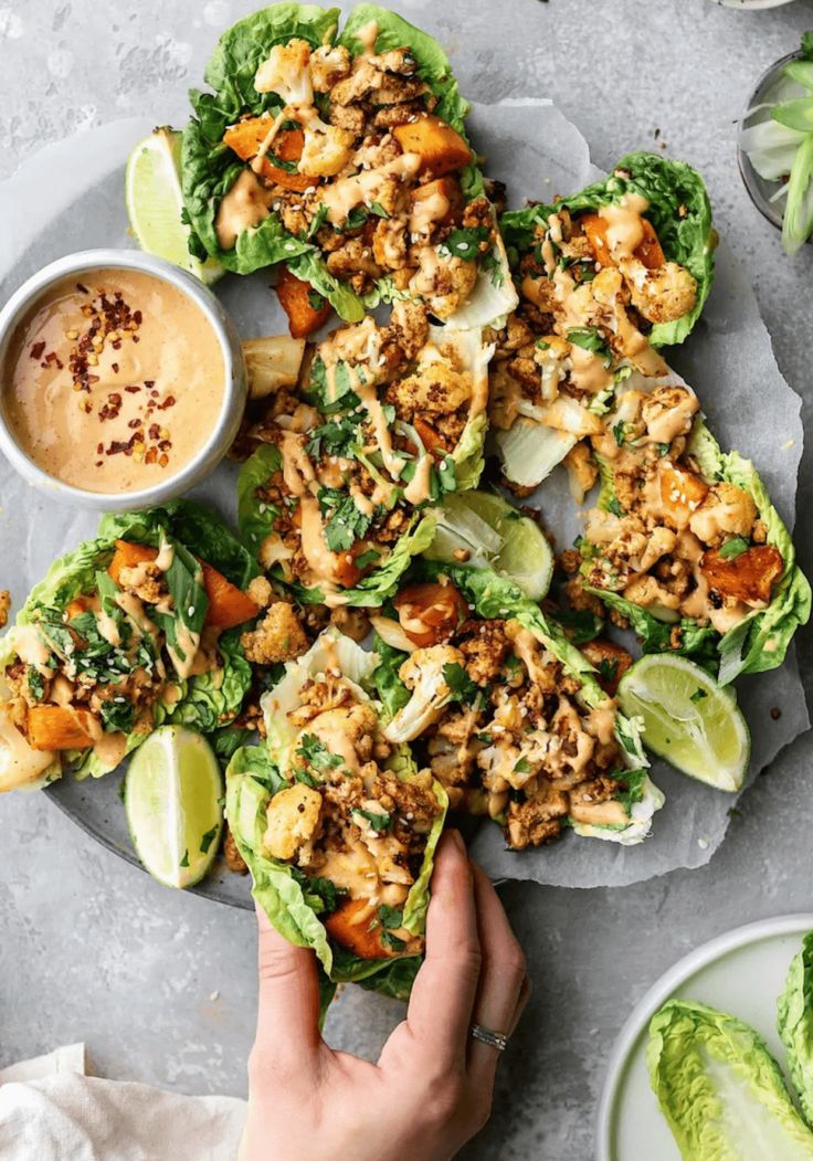 a plate with lettuce wraps and dipping sauce