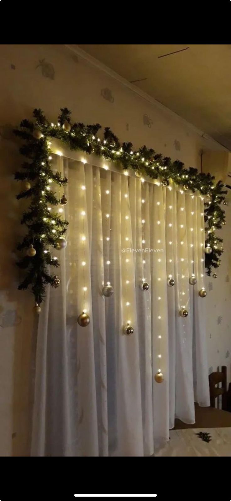 the curtain is decorated with lights and greenery