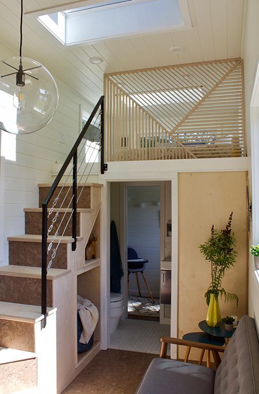 a living room with stairs leading up to the second floor and a loft above it