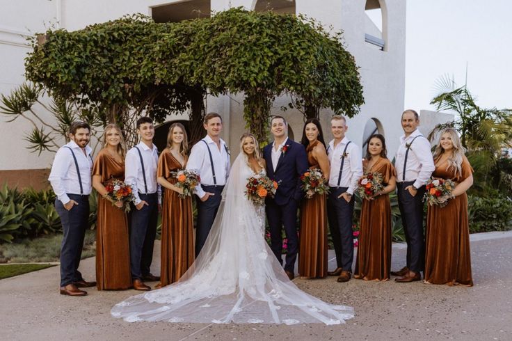 a group of people standing next to each other in front of a building with trees