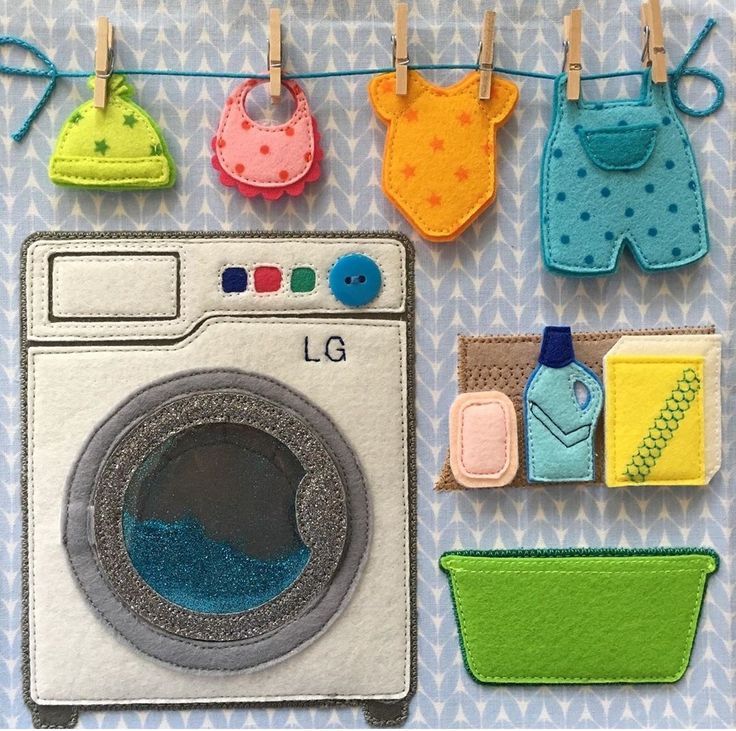 an applique is hanging on a clothes line with laundry and baby items attached to it