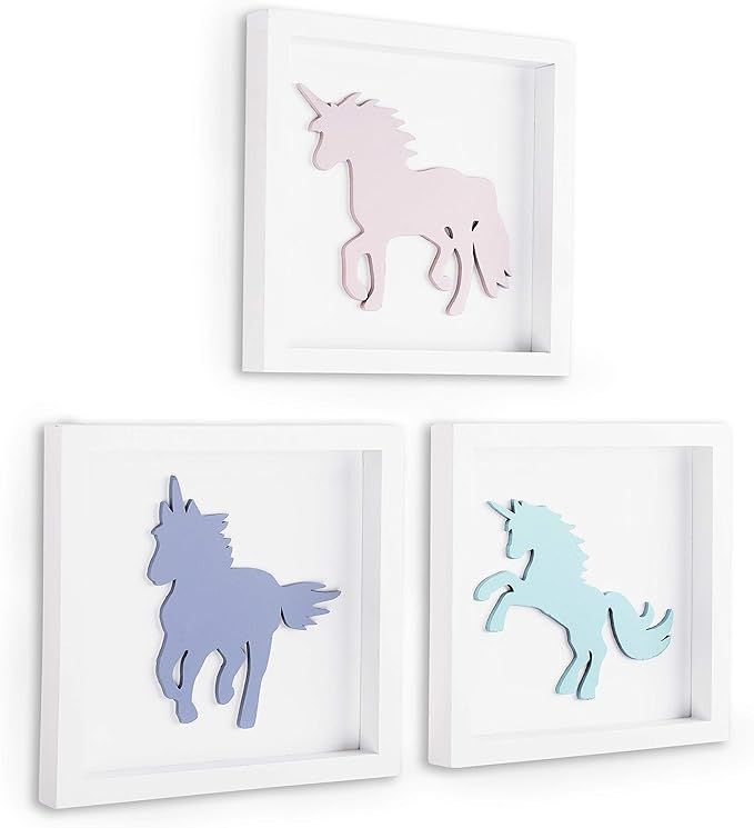 three unicorn cut outs are mounted on the wall in white and pastel blue frames