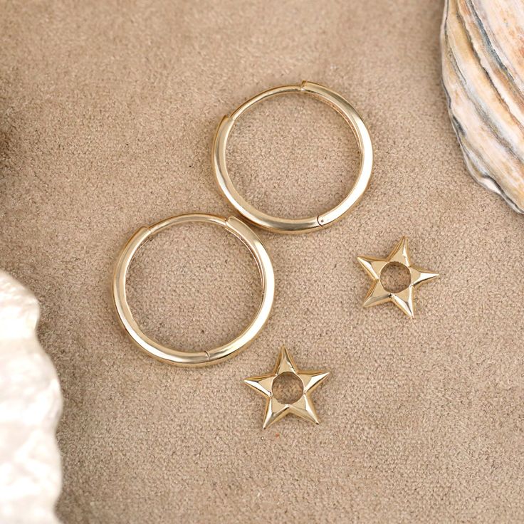 Skylar Baby, you’re a star. Embrace a touch of cosmic charm with these delightful Solid Gold Pointed Star Charm Earrings. Crafted from lustrous 14k gold (available in yellow, white, or rose), these earrings feature dainty star charms that dangle playfully from delicate huggie hoops. Their timeless design adds a subtle shimmer and celestial allure to any outfit. - Handmade- Solid Gold- Diameters: Outer 13 mm - Inner 11 mm- Size of the Star Charm: 7 mm- Hoop Thickness: 1.3 mm * Sold as a pair * Al Celestial Style Gold-plated Yellow Gold Hoop Earrings, Celestial Style Yellow Gold Plated Hoop Earrings, Celestial Yellow Gold Tarnish-resistant Hoop Earrings, Everyday Yellow Gold Earrings With Star Charm, Hypoallergenic 14k Gold Star Jewelry, Single Star-shaped 14k Gold Earring, 14k Gold Star Shaped Pierced Jewelry, 14k Gold Star-shaped Single Earring, Yellow Gold Star-shaped Tarnish Resistant Huggie Earrings