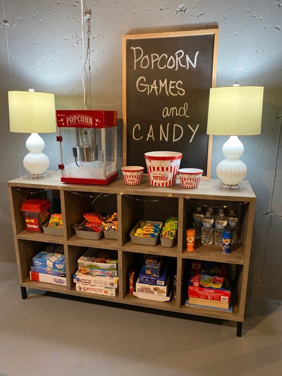 popcorn games and candy are on display in a store with two lamps next to it