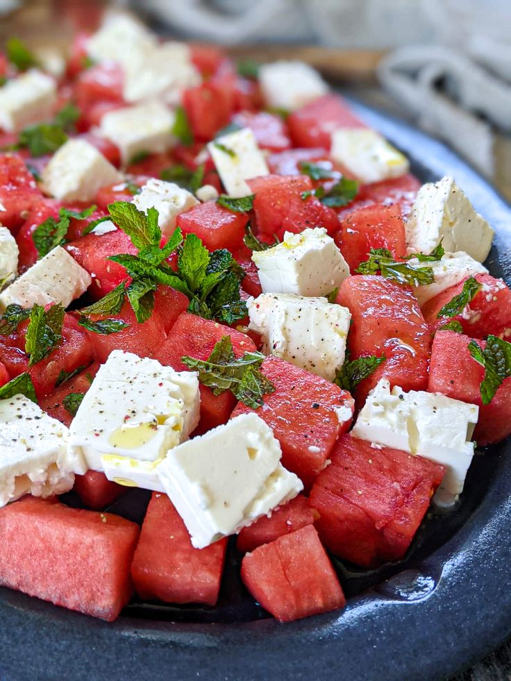 watermelon, feta and mint salad in a blue bowl on a table