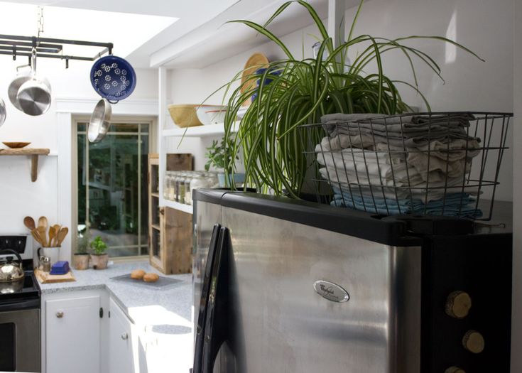 a kitchen with pots and pans hanging from the ceiling, next to an oven