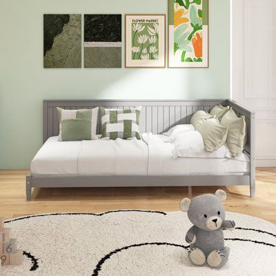 a teddy bear sitting on top of a white bed in a room with green walls