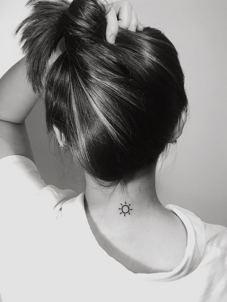 a woman with a small sun tattoo on her neck