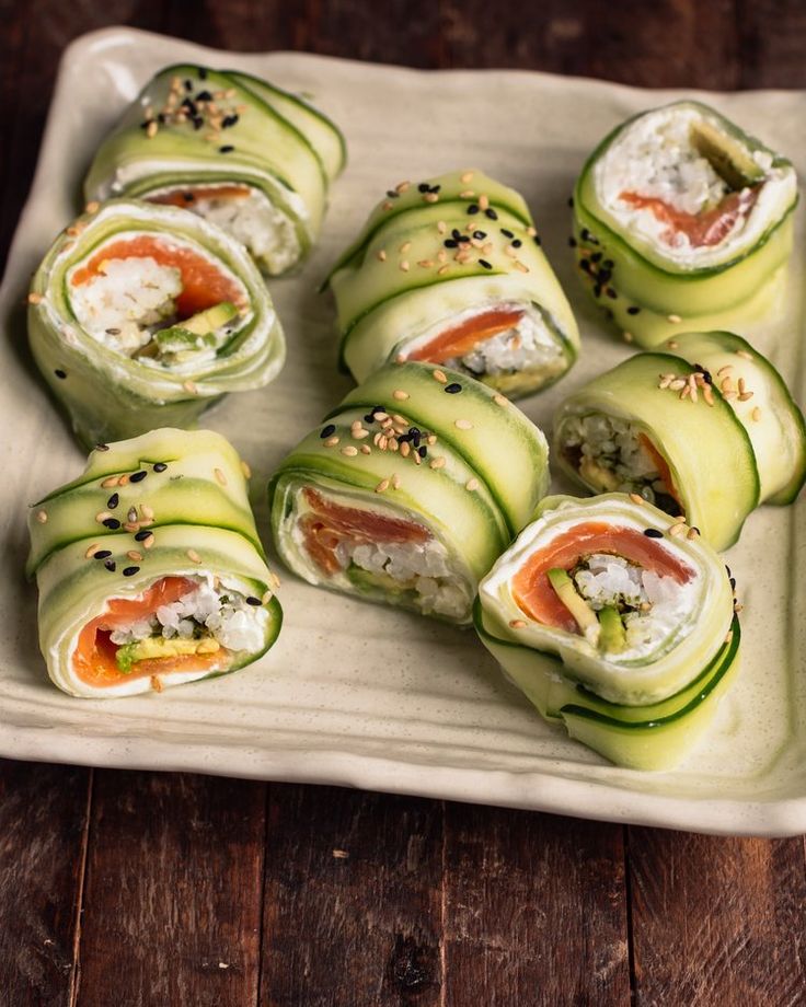 cucumber rolls are arranged on a white plate