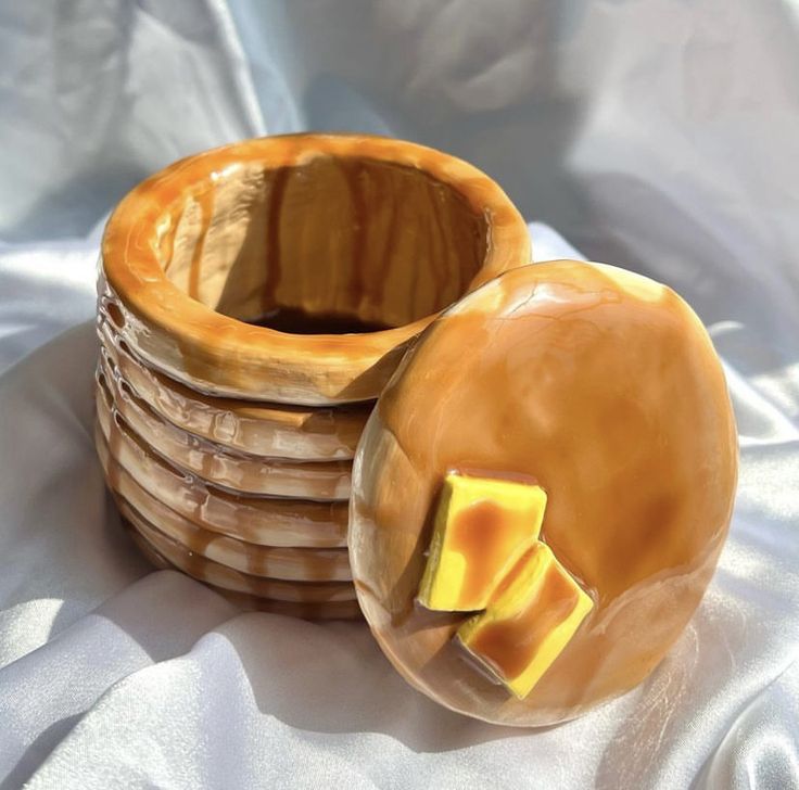 a stack of cheese slices sitting on top of each other next to a wooden bowl