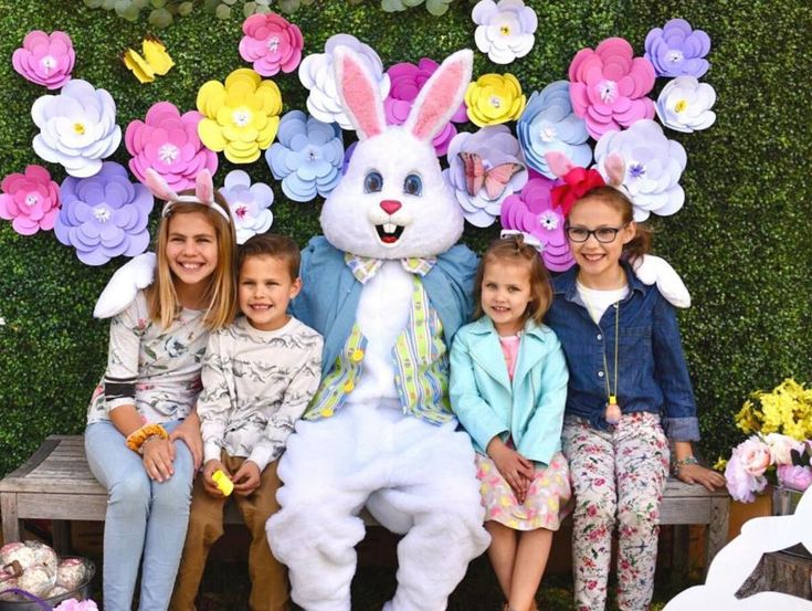 a group of people sitting next to each other in front of an easter bunny costume