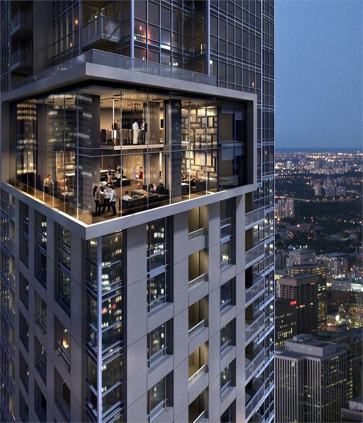 an office building in the middle of a city at night with skyscrapers lit up