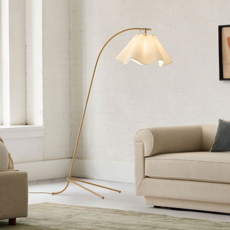 a living room scene with focus on the floor lamp and sofa in the foreground