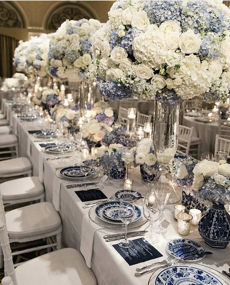 the table is set with blue and white flowers