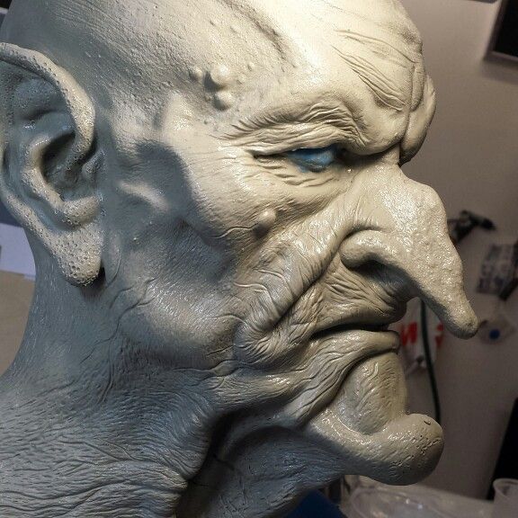 a close up of a statue of an evil man with blue eyes and white hair