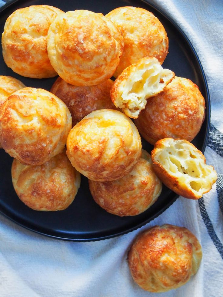 a black plate topped with mini cheese muffins