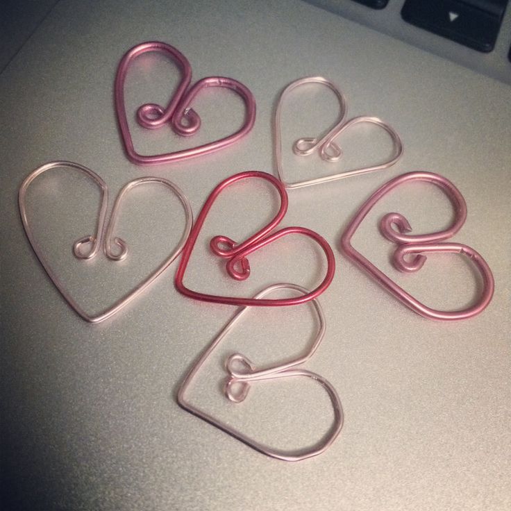 five heart shaped metal clips sitting on top of a laptop computer