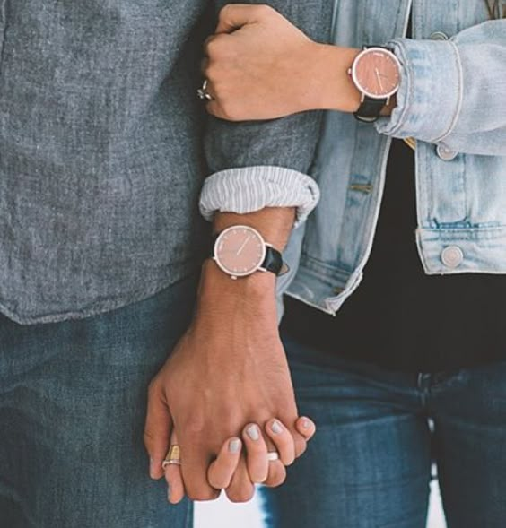 two people holding hands while standing next to each other with their arms around each other