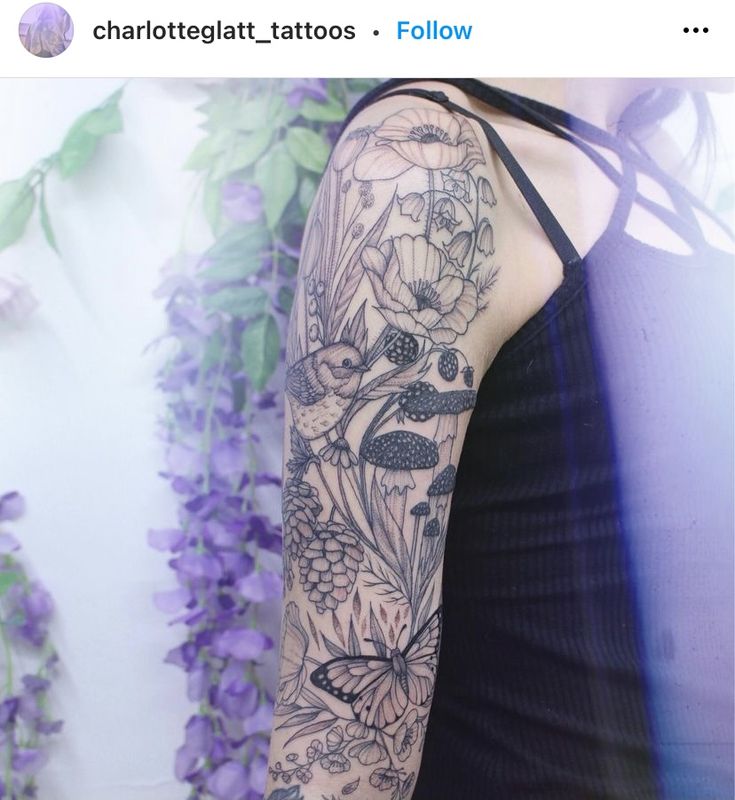 a woman's arm with flowers and butterflies on it, in front of purple flowers