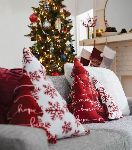 the christmas tree is decorated with red and white pillows