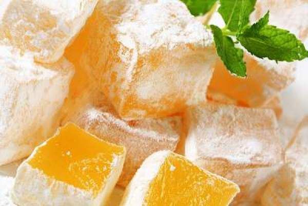 some sugar cubes and orange slices on a white plate with green leafy garnish