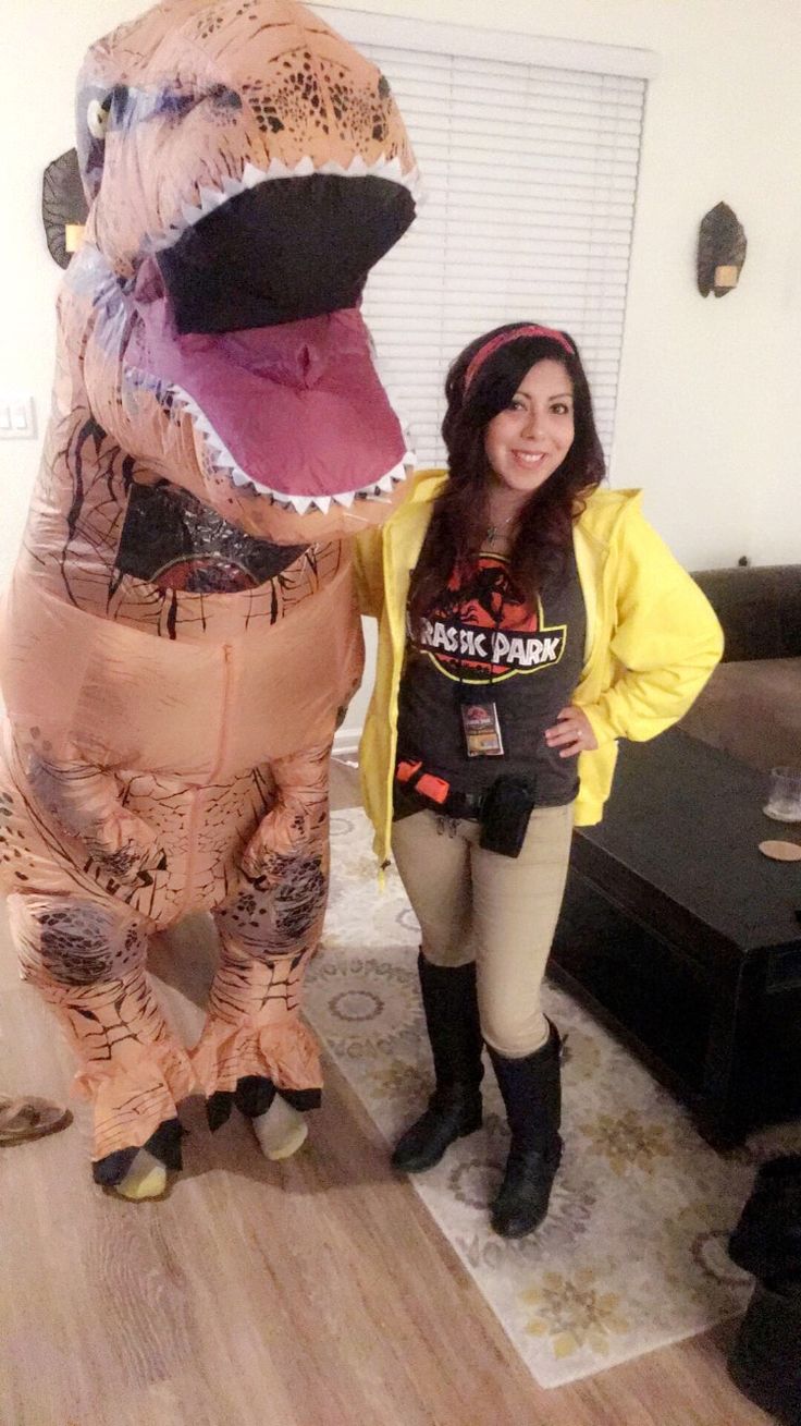 a woman standing next to an inflatable dinosaur