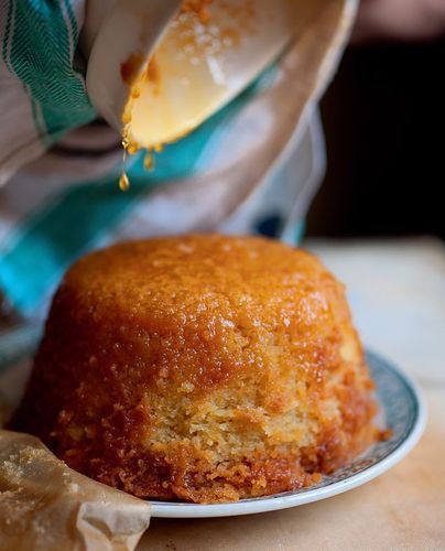 a person pouring syrup over a cake on a plate