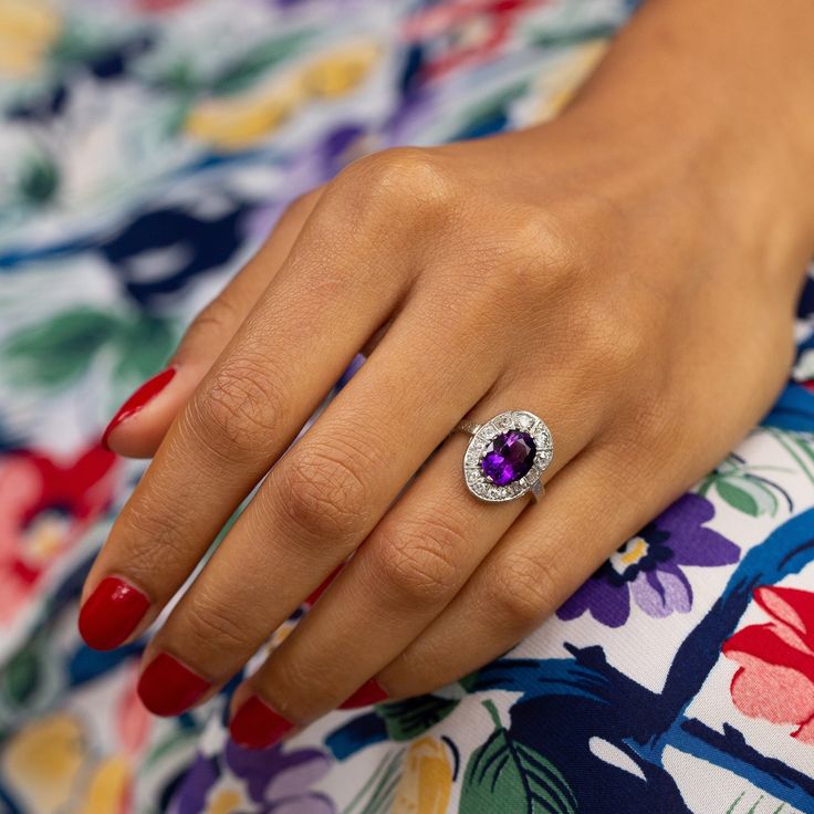 The Story A bright Art Deco ring made circa 1920s-1930s. Crafted in platinum, a richly colored amethyst sits at center. Prong set, it measures 10 mm x 7.8 mm and is a great size in the most lovely purple hue. Surrounding the center stone is a halo of 13 antique cut diamonds, a mixture of Old Mine and Old European cuts, ranging in size from 0.05 to 0.12 carats for a total diamond weight of approximately 0.89 carats. Color and sparkle really come together and make the ring pop. It looks amazing wh Art Deco Amethyst Ring, Ombre Rings, Textured Gold Ring, Sculptural Ring, Gold Knot Ring, Antique Turquoise, Ring Pop, Asscher Cut Diamond, Bright Art