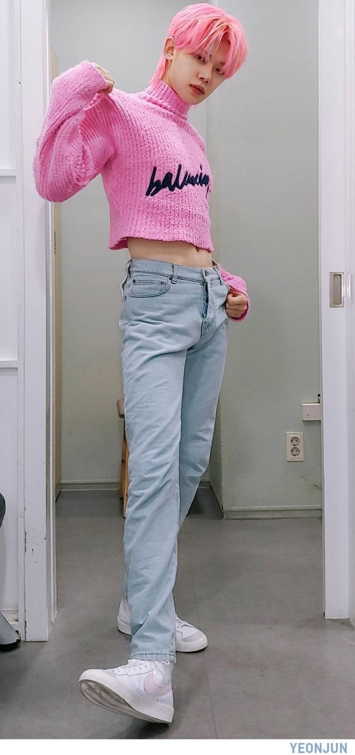 a girl with pink hair wearing a pink sweater and jeans