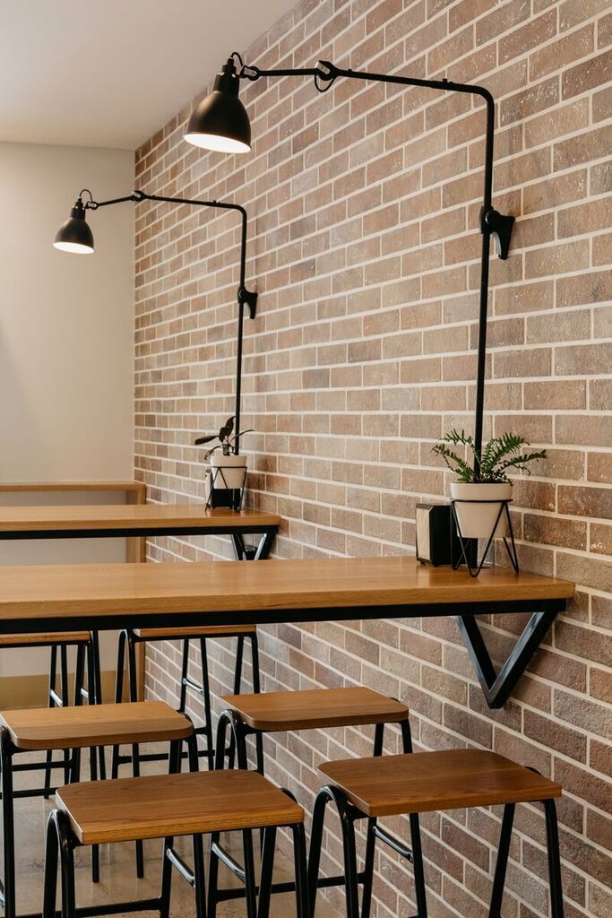 tables and stools are lined up against the brick wall