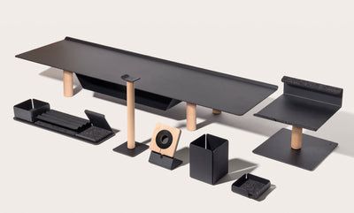 an assortment of black and wood furniture including a computer desk, keyboard, speakers and other accessories