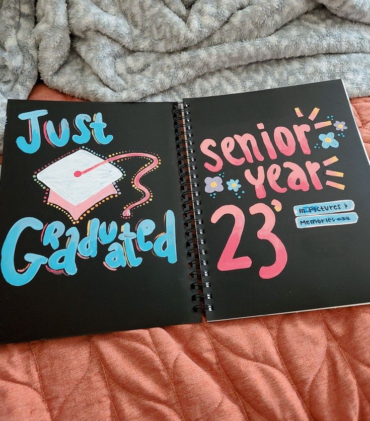 two notebooks with writing on them sitting on a bed