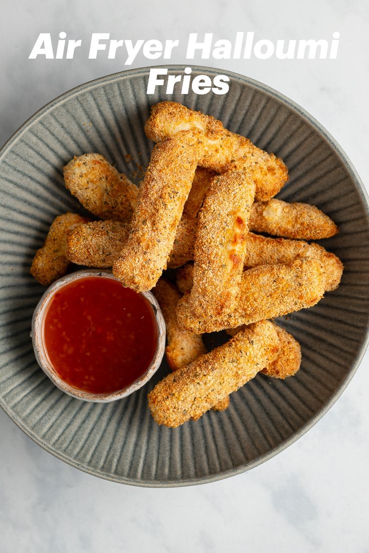 air fryer halloumi fries on a plate with ketchup and dipping sauce