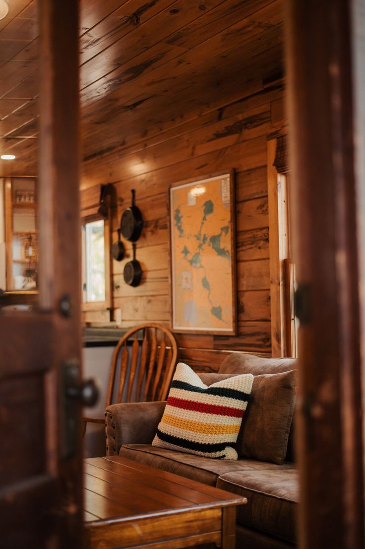 a living room filled with furniture and wooden walls