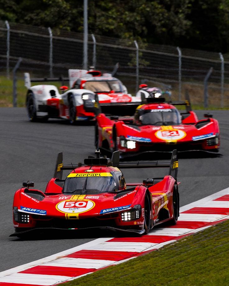 three race cars driving on a track near each other