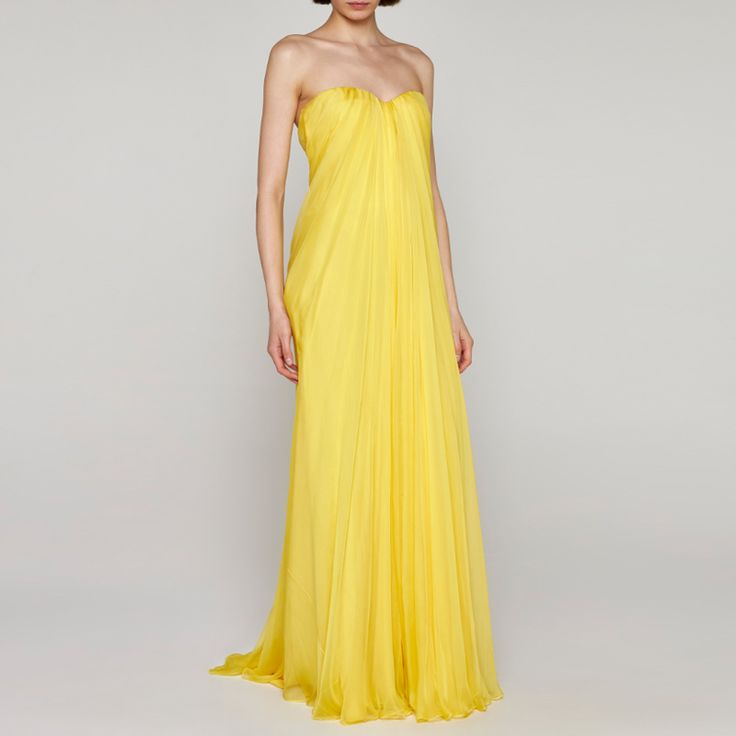 a woman in a yellow dress posing for the camera