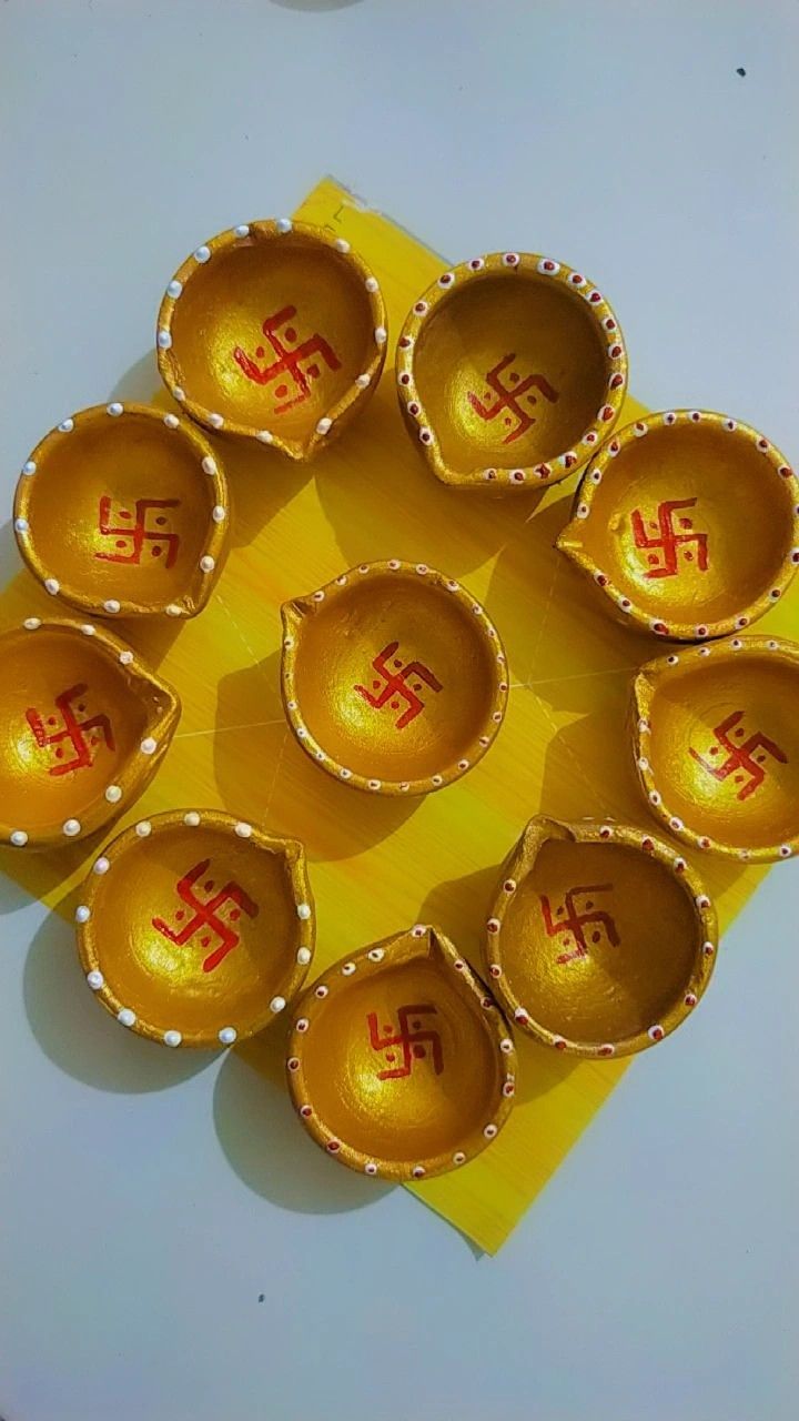 seven golden bowls with symbols on them are arranged in a circle, sitting on top of a yellow piece of paper