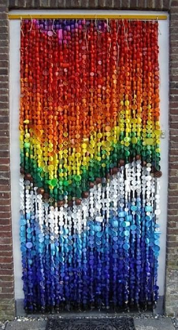 the door is made out of plastic bottle caps and has a rainbow painted on it