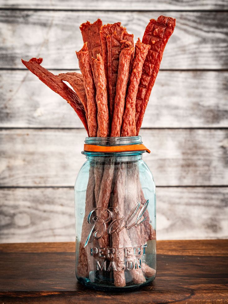 a jar filled with dog treats sitting on top of a wooden table