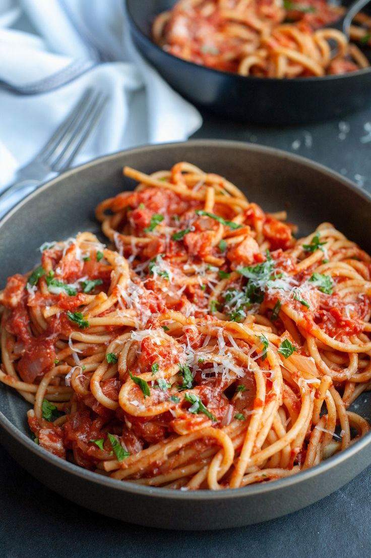 two pans filled with spaghetti and sauce