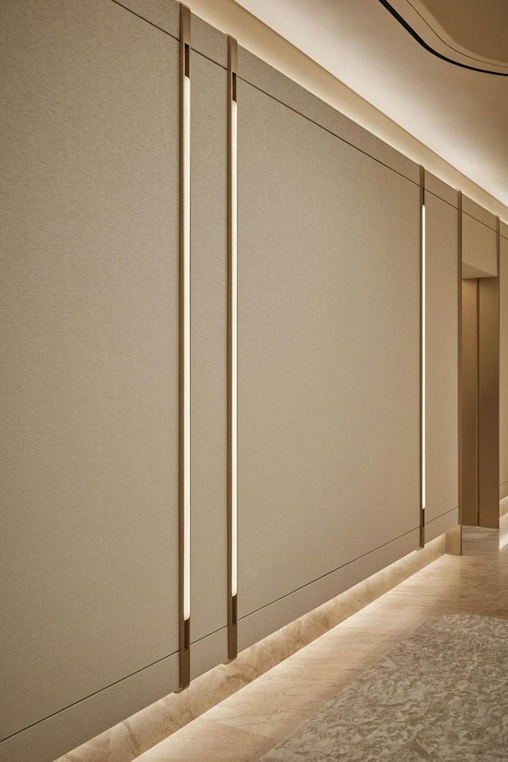 an empty hallway with white walls and beige carpeted flooring is lit by recess lights