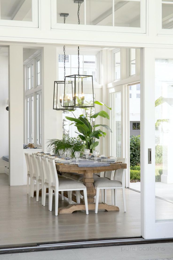 a dining room table with chairs and a potted plant on top of the table