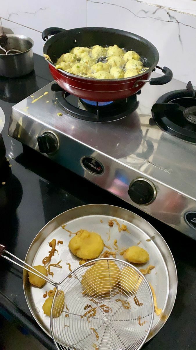 some food is being cooked in a pan on top of the gas stove and ready to be eaten