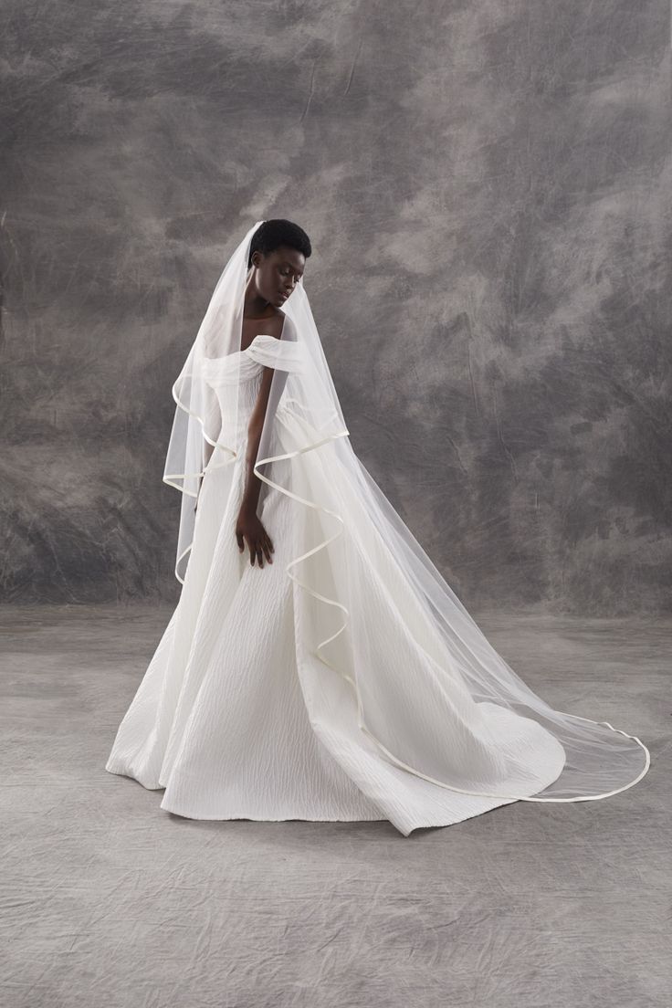 a woman in a white wedding dress and veil