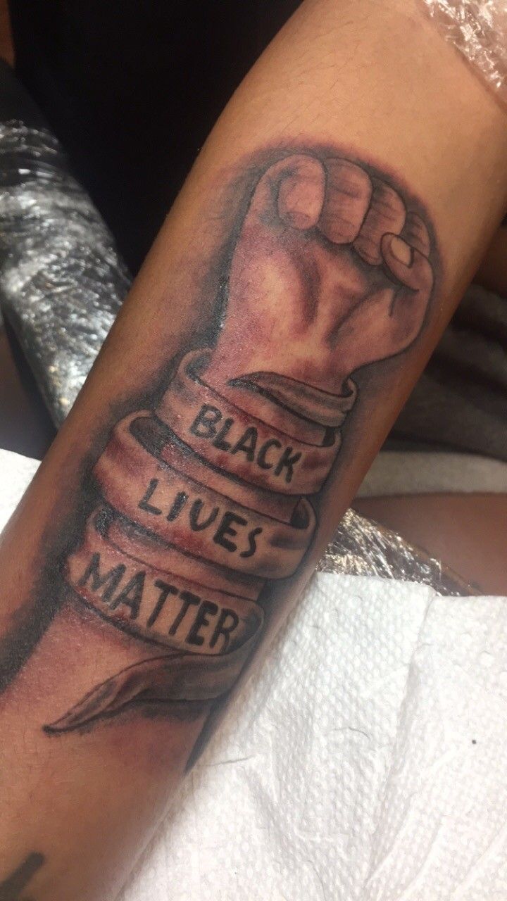 a man with a tattoo on his arm that says black lives matter and a fist