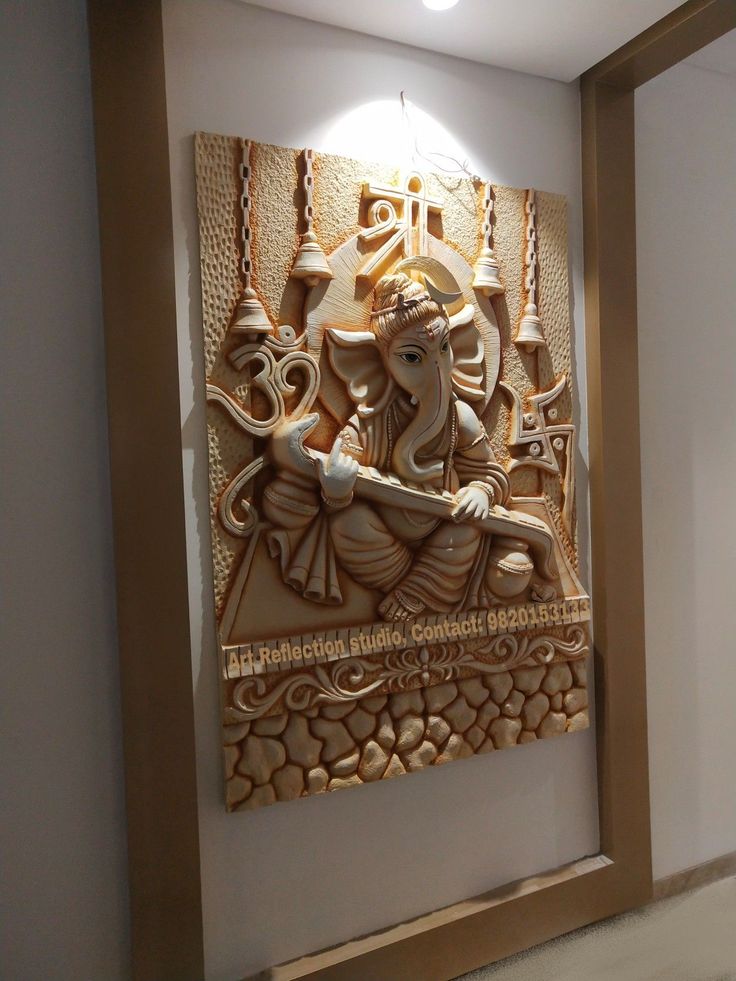 an intricately carved ganesh idol hangs on the wall