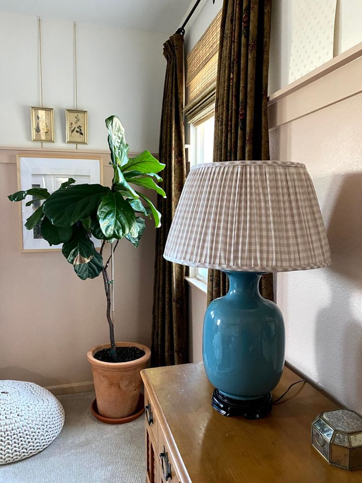 a blue vase sitting on top of a table next to a lamp