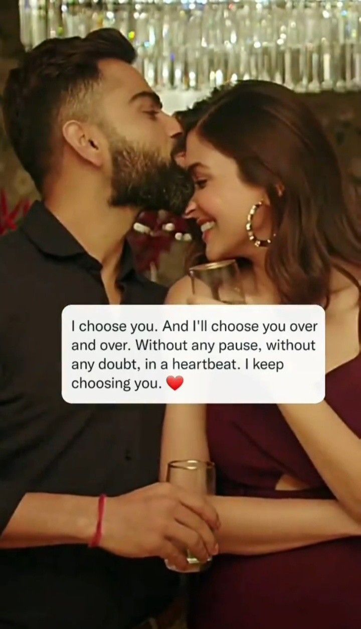 a man and woman sharing a kiss in front of a wine rack with bottles behind them