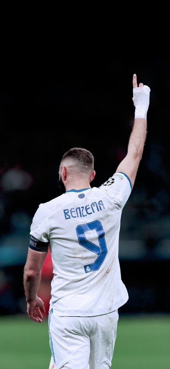 a male soccer player is holding his hand up in the air