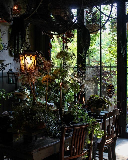 the dining room table is surrounded by potted plants and other greenery in front of an open glass door